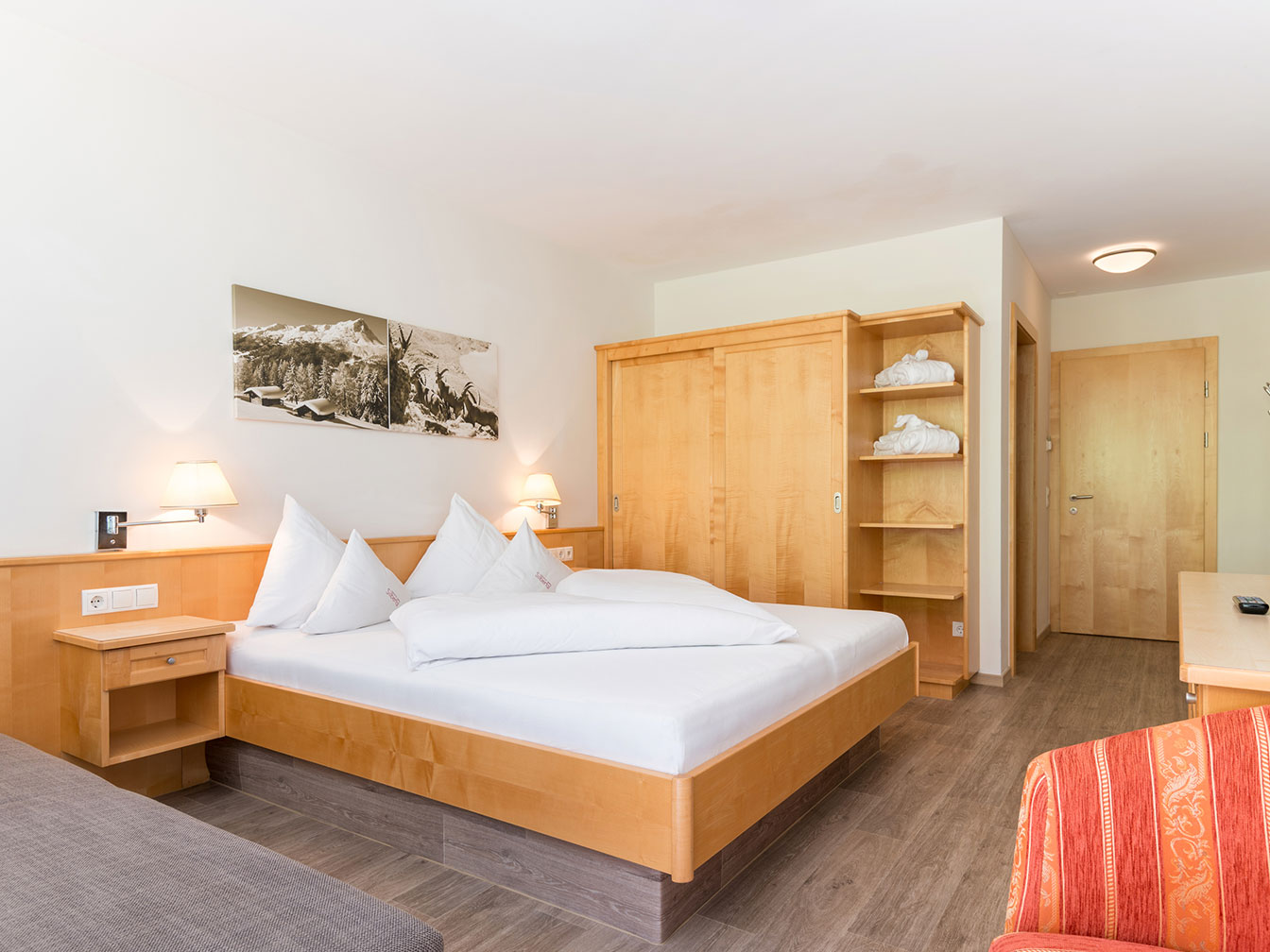 Doppelbett und Kleiderschrank im Doppelzimmer Silbertal des Hotel Silbertal
