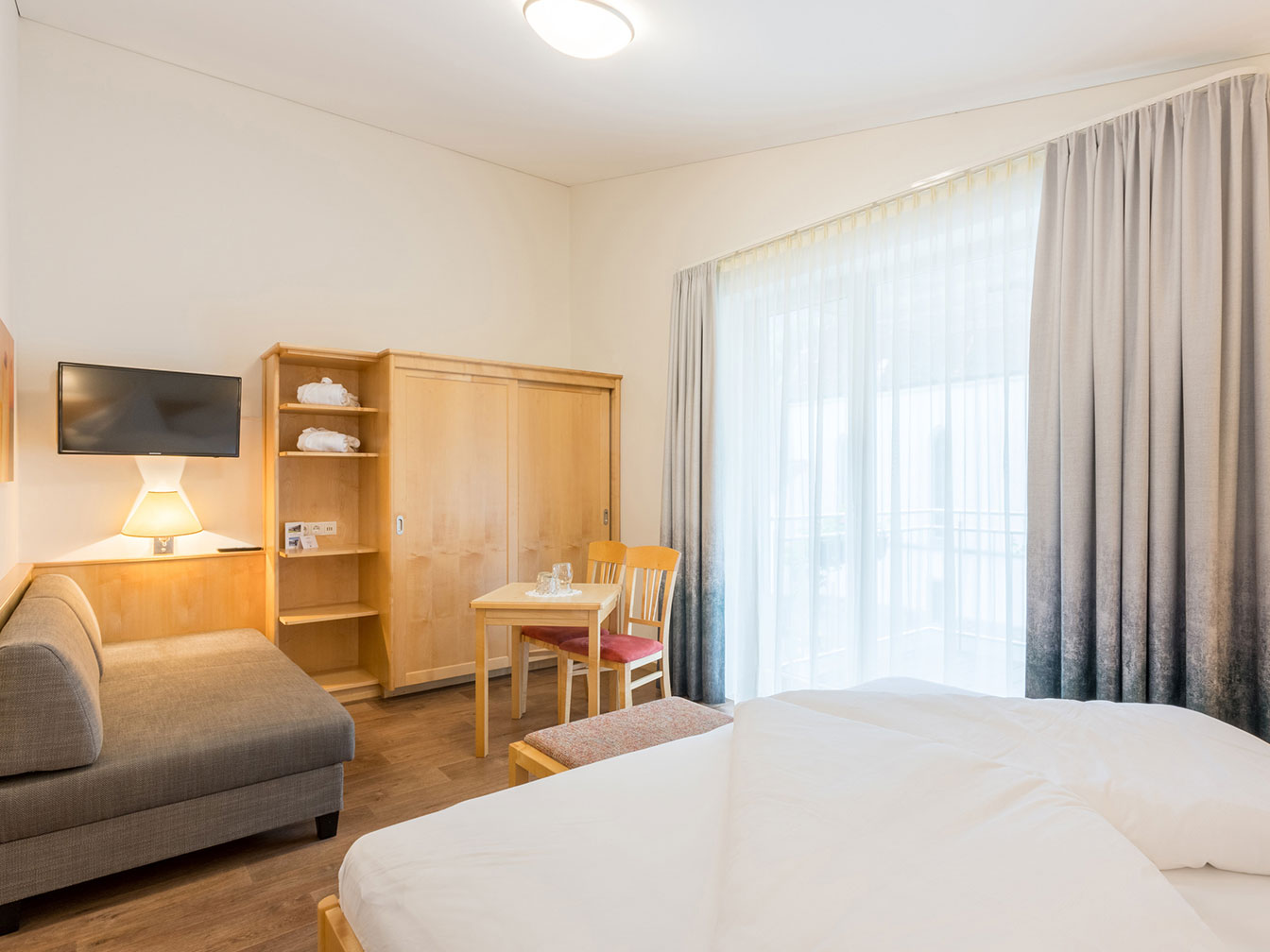 Wohnbereich mit Schlafcouch, TV und Sitzgelegenheit im Romantikzimmer 108 des Hotel Silbertal